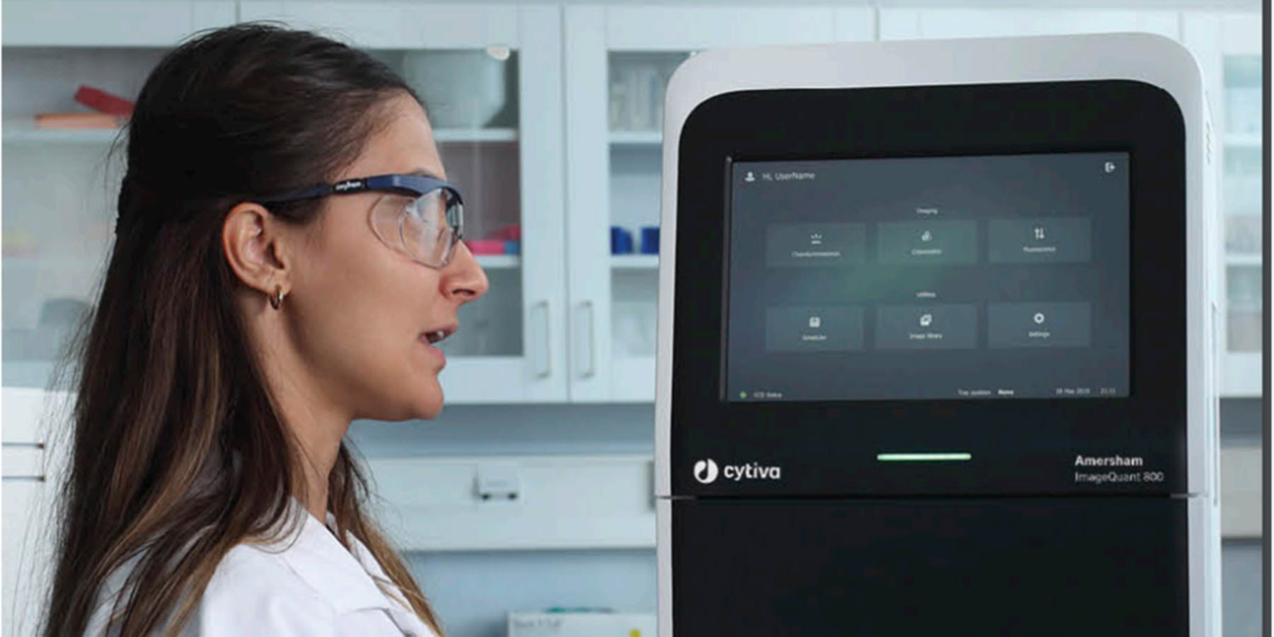 A photo of a female scientist working with the Cytiva ImageQuant 800 imager