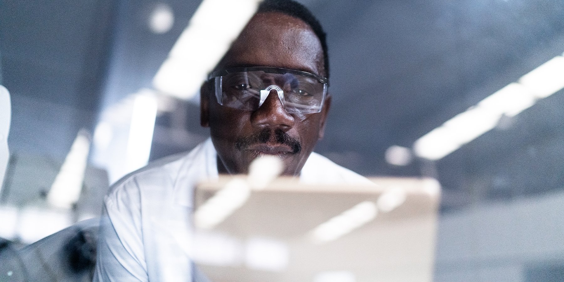 Male scientist in the lab looking at a tablet